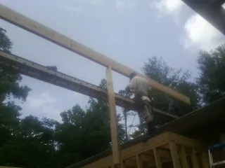 Carpenter setting a ridge beam over a new addition frame — Ice Dam Removal by Roofing Brothers in Hammonton