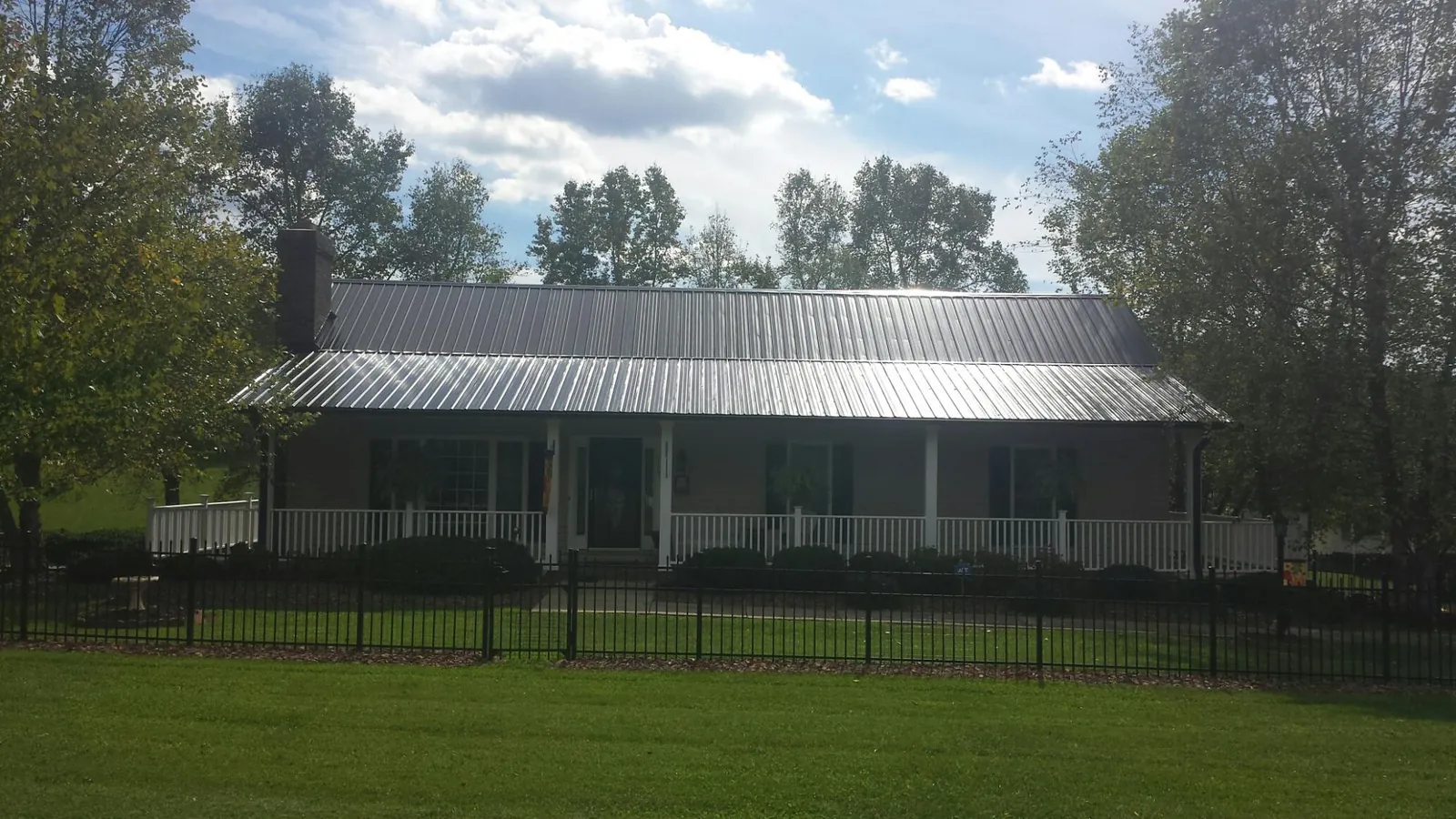 Gray metal roof on a brick ranch with a full width front porch — Gutter Guard Installation work by our crew in Hammonton