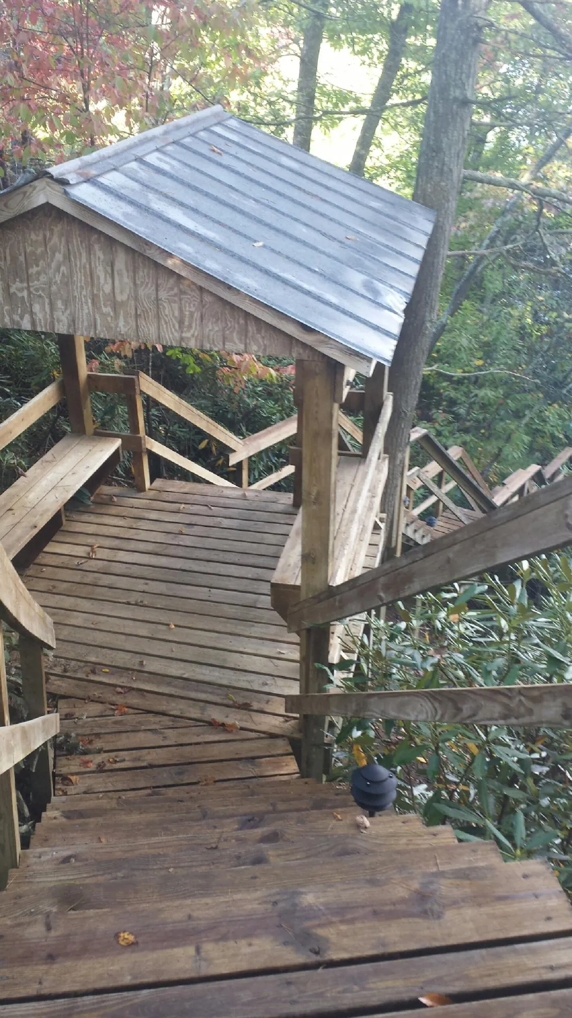 Metal roofed shelter over wooden steps on a wooded walkway — Skylight Repair & Installation work by our crew in Hammonton